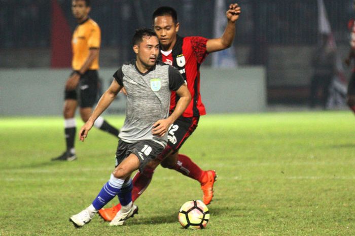 Pemain tengah Persela asal Jepang, Shohei Matsunaga (depan) mencoba lepas dari pengawalan pilar Persipura pada laga turnamen pramusim Jakajaya Friendly Game 2018 di Stadion Surajaya, Lamongan, Jumat (9/3/2018) malam. 