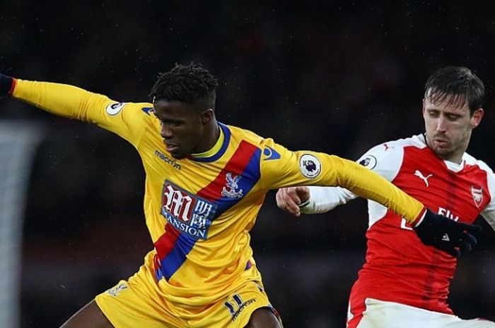 Wilfried Zaha tengah memperebutkan bola dengan Nacho Monreal dalam laga Premier League antara Arsenal kontra Crystal Palace di Emirates Stadium, 01 Januari 2017. 