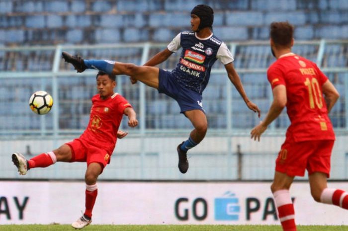 Gelandang Arema FC, Jayus Hariono berebut  bola dihalangi striker  Barito Putera, Samsul Arif dalam 