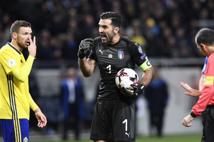 Wasit Cuneyt Cakir (kanan) menenangkan kiper Italia, Gianluigi Buffon (tengah), dan striker Swedia, Marcus Berg, dalam laga play off Kualifikasi Piala Dunia 2018 Zona Eropa di Solna, Swedia, pada 10 November 2017.