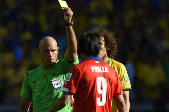 Wasit asal  Inggris, Howard Webb, memberi kartu kuning ke pemain Chile, Mauricio Pinilla, saat pertandingan 16 besar Piala Dunia FIFA 2014 antara Brasil dan Cile di Stadion The Mineirao di Belo Horizonte  pada 28 Juni 2014.