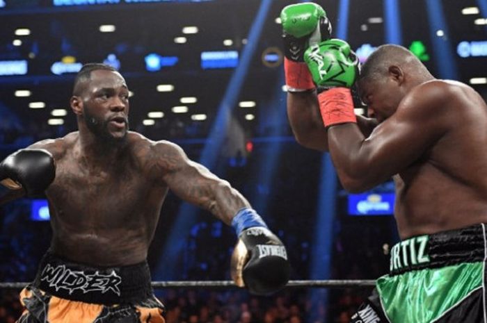 Petinju Amerika Serikat, Deontay Wilder (kiri), melayangkan pukulan ke arah petinju Kuba, Luis Ortiz, di New York, AS, Sabtu (3/3/2018) malam waktu setempat.