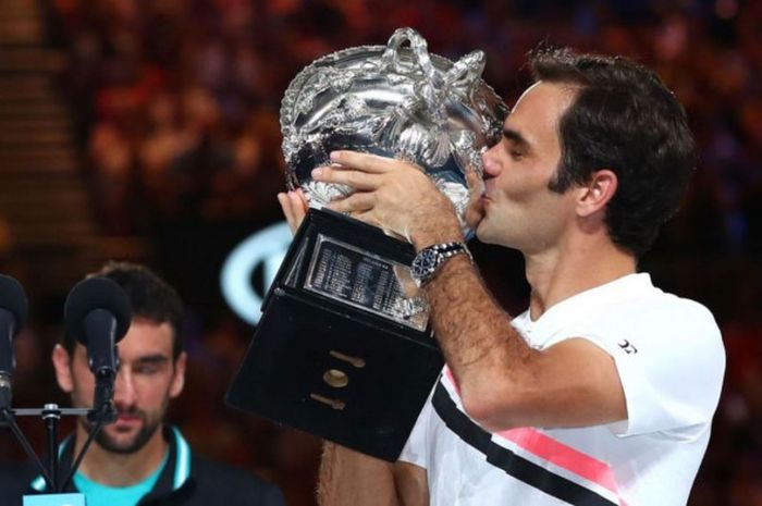 Petenis tunggal putra Swiss, Roger Federer, mencium trofi yang dia raih seusai menjuarai turnamen Gr