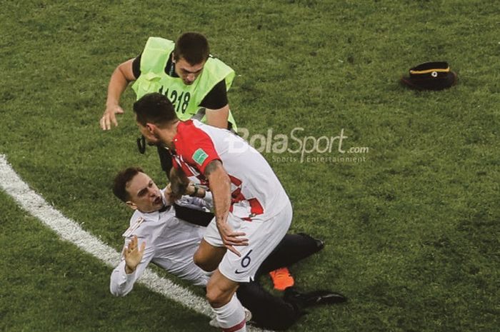 Bek timnas Kroasia, Dejan Lovren, membanting seorang penyusup saat laga final Piala Dunia 2018 berakhir dengan kemenangan 4-2 Prancis, di Stadion Luzhniki, Moskow, pada Minggu (15/07/2018).