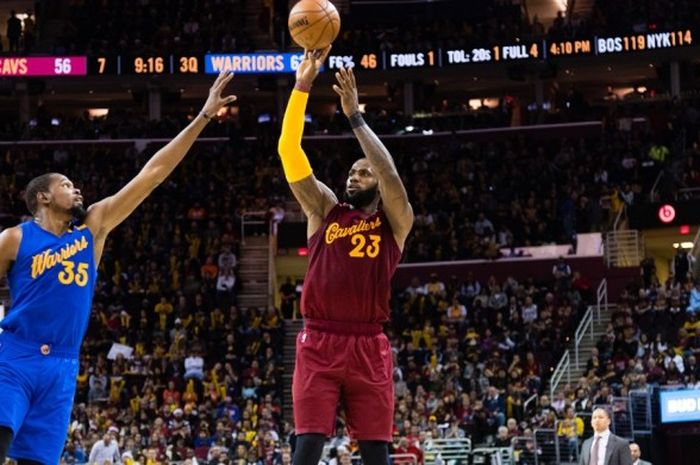 Forward Cleveland Cavaliers, LeBron James (jersey merah, #23), melepas tembakan seraya dijaga pemain Oklahoma City Thunder, Kevin Durant (#35), saat menjalani big match musim reguler NBA 2016-2017 di Quicken Loans Arena, Cleveland, Ohio, Amerika Serikat, Minggu (25/12/2016) malam waktu setempat. Cavaliers menang tipis 109-108.