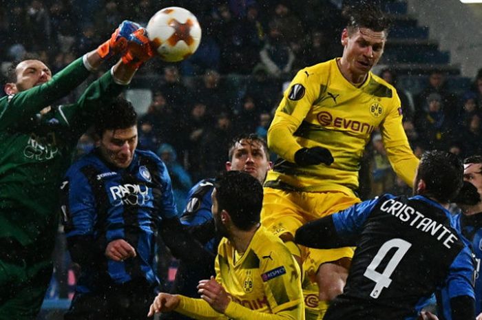 Aksi kiper Atalanta, Etrit Berisha (baju hijau), saat meninju bola untuk mengamankan gawangnya dari ancaman para pemain Borussia Dortmund (berbaju kuning) dalam laga leg 2 babak 32 besar Liga Europa 2017-2018 di Stadion MAPEI, Reggio Emilia, Italia, pada Kamis (22/2/2018).