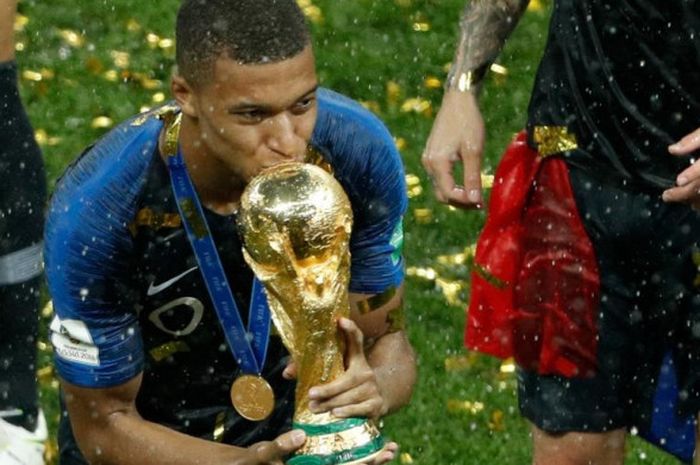   Penyerang Prancis, Kylian Mbappe, mencium trofi juara Piala Dunia 2018 setelah timnya menekuk Kroasia 4-2 pada laga final di Stadion Luzhniki, Moskow, 15 Juli 2018.  