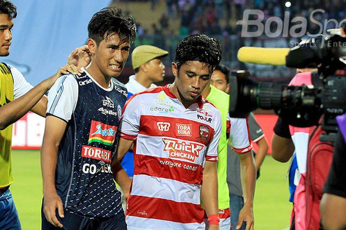 Bek Madura United, Beni Wahyudi (kanan), menenangkan gelandang Arema FC, Hanif Sjahbandi, usai Madura United mengalahkan Arema FC dalam laga pekan kelima Liga 1 2018 di Stadion Gelora Ratu Pamelingan, Pamekasan, Sabtu (21/4/2018).