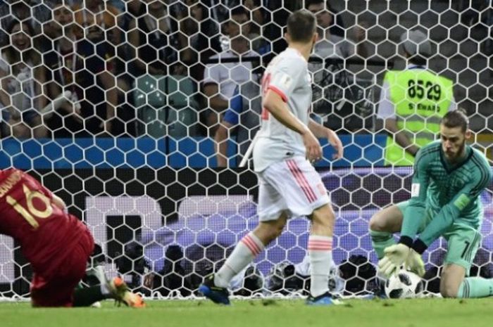 Kiper Spanyol, David De Gea (kanan) gagal mengamankan bola hasil sepakan keras penyerang Portugal, Cristiano Ronaldo dalam pertandingan penyisihan Grup B di  Fisht Stadium, 15 Juni 2018. 