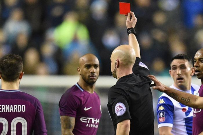 Wasit Anthony Taylor (tengah) memberikan kartu merah untuk bek kiri Manchester City, Fabian Delph, dalam laga babak kelima Piala FA kontra Wigan Athletic di Stadion DW, Wigan, Inggris, pada 19 Februari 2018.