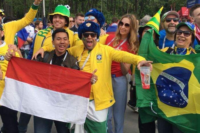 Mahasiswa asal Indonesia, Garin Yudha Primaditya, berpose dengan fans asal Brasil pada laga pembukaan Piala Dunia 2018 di Stadion Luzhniki, Moskow, 14 Juni 2018.