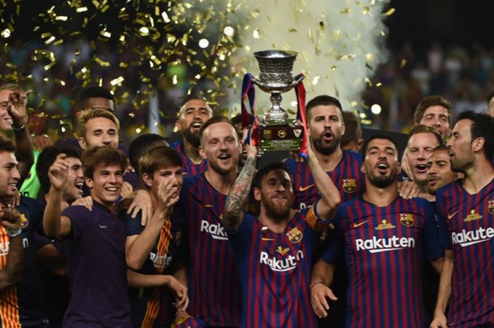 Megabintang FC Barcelona, Lionel Messi (tengah), mengangkat trofi Piala Super Spanyol seusai mengalahkan Sevilla di Grande Stade de Tanger, Tangiers, Maroko pada 12 Agustus 2018.