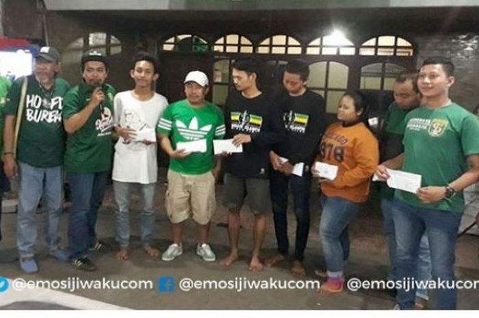 Bonek dan perwakilan Persebaya saat memberikan santunan untuk korban kekerasan dan kecelakaan.