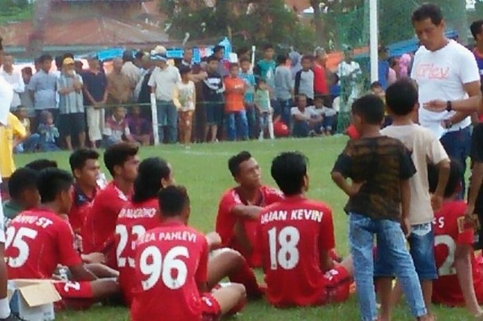 Pelatih Semen Padang U-19, Weliansyah (dua dari kanan) memberikan arahan ke anak asuhnya saat jeda laga kontra Garuda FC Payakumbuh pada turnamen Piala Bupati 50 Kota di lapangan Simalanggang, Kabupaten 50 Kota, Jumat (14/4/2017). 