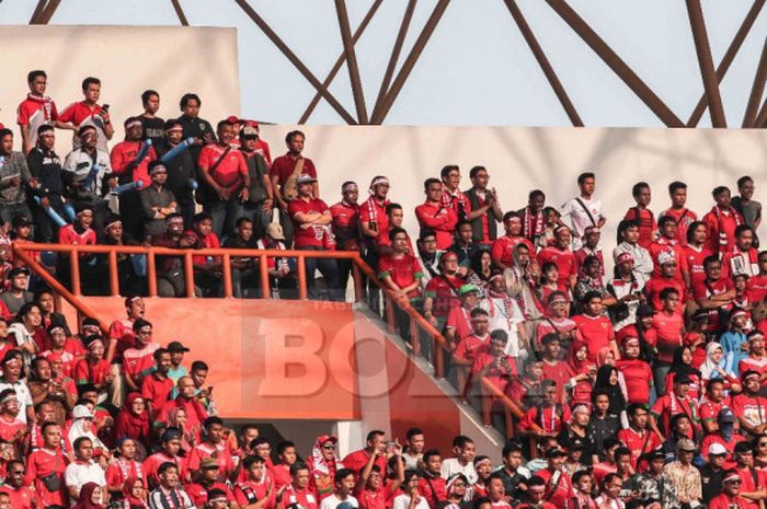 Suporter Indonesia mendukung perjuangan tim nasional U-23 Indonesia saat melawan  Uni Emirat Arab  dalam pertandingan babak 16 besar sepak bola Asian Games 2018 di Stadion Wibawa Mukti, Jumat (24/8/2018). 