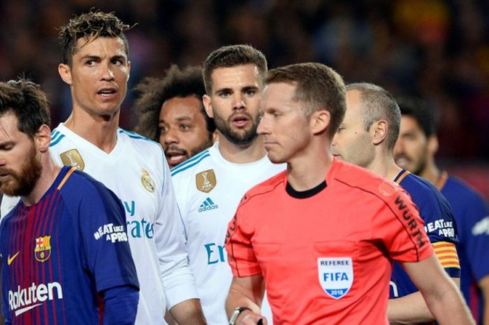 Wasit Alejandro Hernandez melewati megabintang Real Madrid, Cristiano Ronaldo (kedua dari kiri), dan megabintang FC Barcelona, Lionel Messi (kiri), dalam laga Liga Spanyol di Stadion Camp Nou, Barcelona pada 6 Mei 2018.