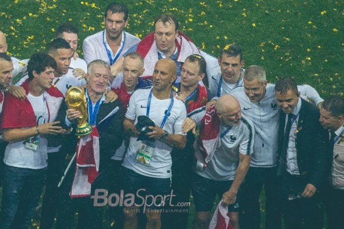 Pelatih Prancis, Didier Deschamps, memegang  trofi juara Piala Dunia 2018 didampingi stafnya setelah menekuk Kroasia 4-2 pada laga final di Stadion Luzhniki, Moskow, 15 Juli 2018.