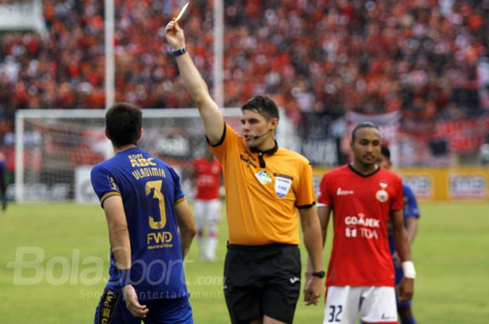 Wasit Evans Shaun Robert beri kartu kuning pada pemain Persib Vladimir Vujovic.