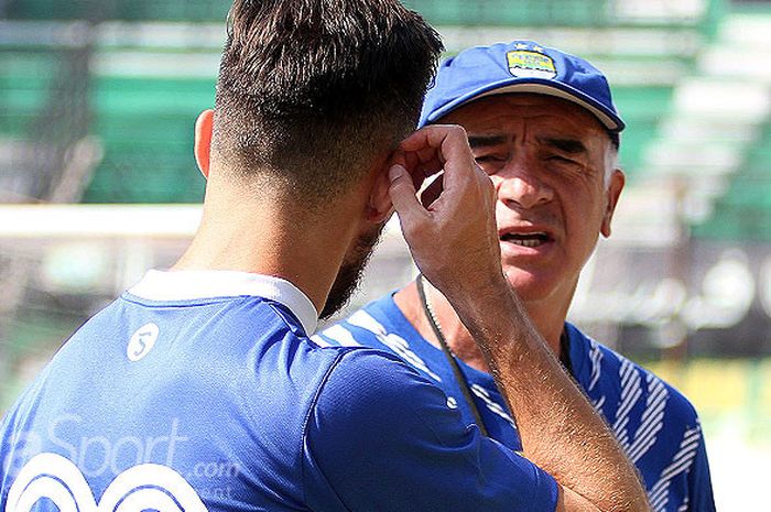 Pelatih Persib Bandung, Roberto Carlos Mario Gomez, berdiskusi dengan striker Jonathan Bauman dalam sesi latihan di Gelora Bung Tomo Surabaya, Rabu (25/7/2018).