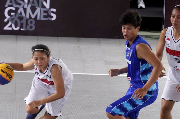 Pemain tim basket 3x3 putri Indonesia, Agustin Elya Gradita Retong (kiri), melewati pemain Thailand pada laga babak penyisihan grup test event Asian Games 2018, di Center Court, GBK, Senayan, Jumat (1/12/2017).