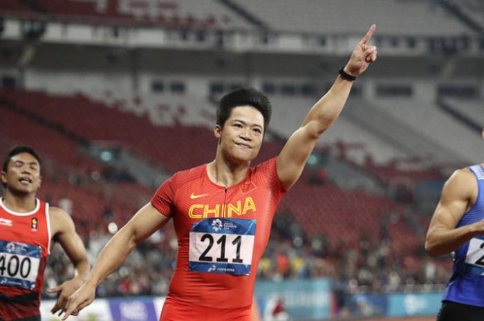 Pelari Cina Su Bingtian (tengah) mengacungkan tangannya seusai menjadi yang tercepat dalam final lari 100m putra Asian Games ke-18 di Stadion Utama Gelora Bung Karno, Jakarta, Minggu (26/8). 