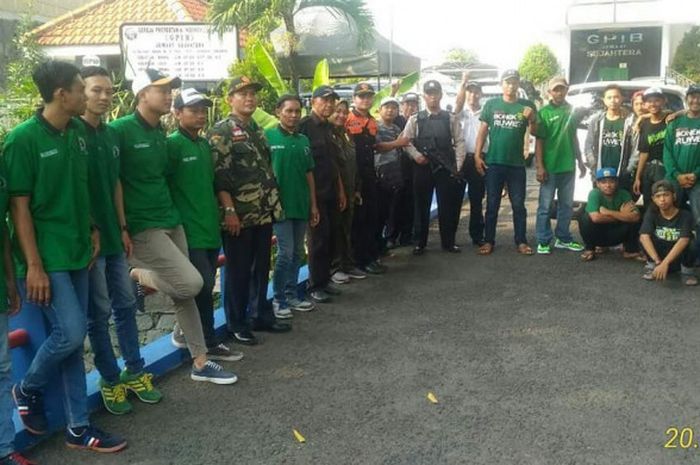 Bonek bersama dengan kepolisian dan linmas menjaga ibadah di salah satu gereja di Kutisari, Minggu (20/5/2018).