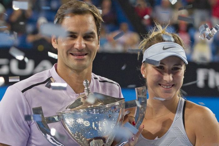 Dua petenis Swiss, Roger Federer (kiri) dan Belinda Bencic, berpose dengan Piala Hopman 2018 yang mereka raih setelah memenangi laga final atas Jerman dengan skor 2-1 di Perth Arena, Perth, Australia, Minggu (6/1/2018).