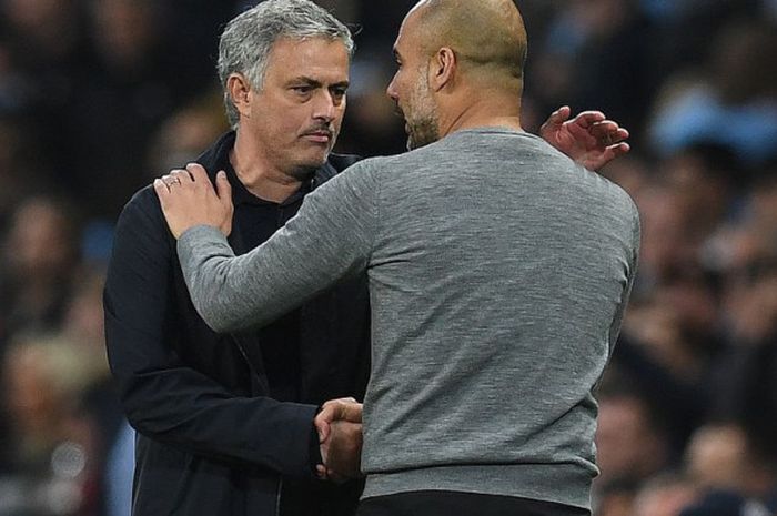   Pelatih Manchester United, Jose Mourinho (kiri) bercengkerama dengan pelatih Manchester City, Pep Guardiola, seusai laga Derbi Manchester di Stadion Etihad, Manchester, pada Sabtu (7/4/2018).  