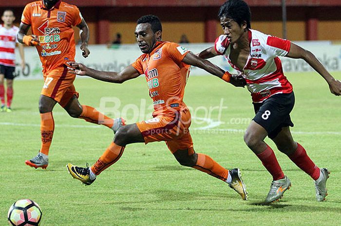 Pemain sayap Pusamania Borneo FC, Terens Puhiri (kiri), mengejar bola dibayangi pemain Madura United, Bayu Gatra, dalam laga pekan 2ke-9 Liga 1 di Stadion Ratu Pamellingan Pamekasan, Jawa Timur, Jumat  (13/10/2017) malam.