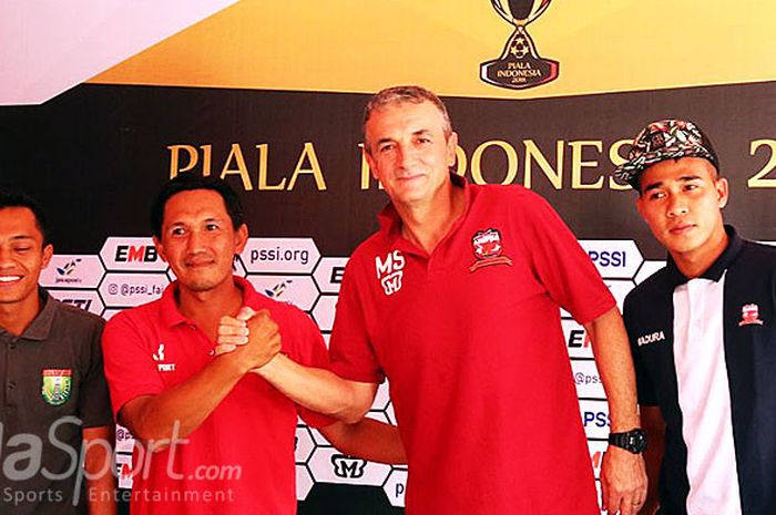 Pelatih Persibo, Jordi Kartiko (kedua dari kiri), berjabat tangan dengan pelatih Madura United, Milomir Seslija (kedua dari kanan), dalam sesi jumpa pers di Stadion Letjen H. Soedirman Bojonegoro, menjelang laga pembuka Piala Indonesia.