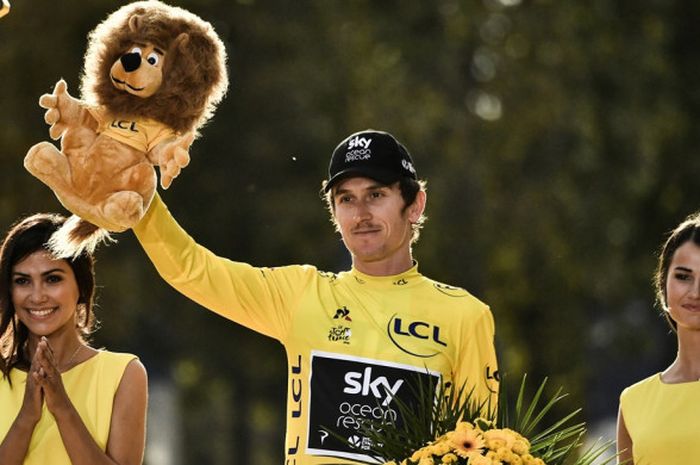 Pebalap sepeda Britania Raya, Geraint Thomas, melakukan selebrasi di atas podium setelah memastikan menjuarai Tour de France 2018, Sabtu (29/7/2018). 