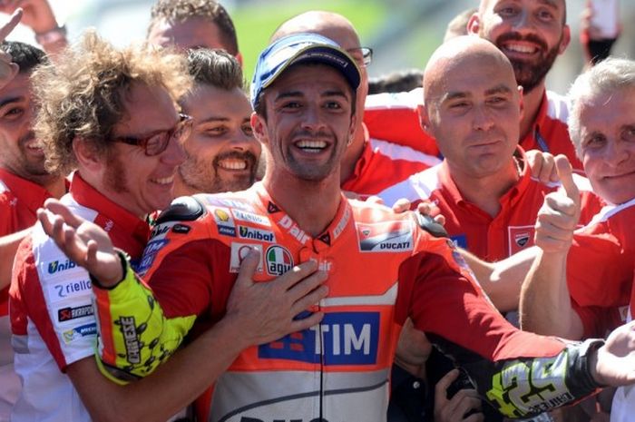 Pebalap Ducati, Andrea Iannone (tengah), merayakan kemenangan GP Austria di Red Bull Ring, Spielberg, Minggu (14/8/2016), bersama rekan-rekan setimnya.