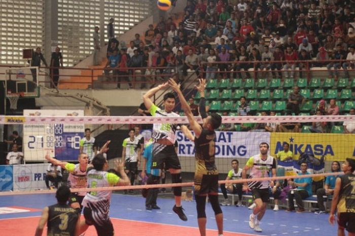 Pemain tim bola voli putra Jakarta Pertamina Energi, Gunawan Saputra (jersey putih-hijau) bersiap melakukan smes ke arah Jakarta BNI Taplus pada putaran kedua final four Proliga 2018 di GOR Sritex Arena, Solo, Jumat (6/4/2018).