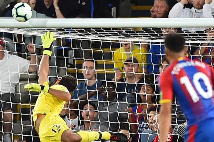 Kiper Liverpool FC, Alisson Becker, berusaha menepis tendagan gelandang Crystal Palace, Andros Townsend, dalam laga Liga Inggris di Stadion Selhurst Park, London pada 20 Agustus 2018.