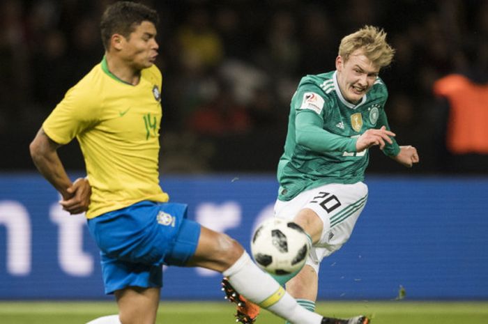 Bek tim nasional Brasil, Thiago Silva (kiri), saat mencoba memblok tembakan dari penyerang Jerman, Julian Brandt, dalam laga uji coba di Olimpiastadion, Berlin, Jerman, pada Selasa (27/3/2018).