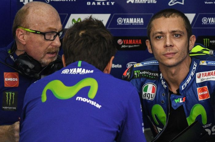 Pebalap Movistar Yamaha MotoGP, Valentino Rossi, mendengarkan instruksi dari kru timnya saat melakoni sesi latihan pertama GP Malaysia di Sirkuit Internasional Sepang, Jumat (27/10/2017).