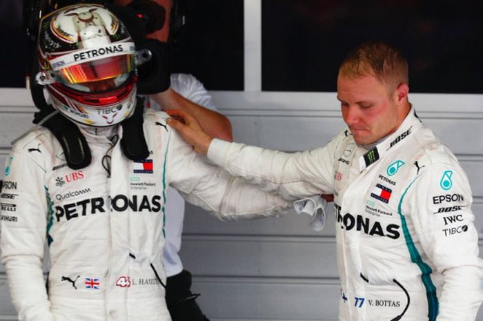 Lewis Hamilton (kiri) saat menghampiri rekan setimnya di Mercedes, Valtteri Bottas (kanan), beberapa saat setelah sesi balapan F1 GP Rusia 2018 usai digelar pada Minggu (30/9/2018).