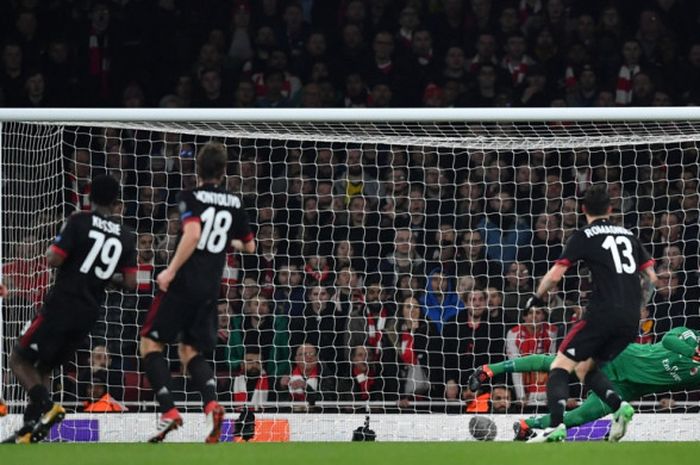 Kiper AC Milan, Gianluigi Donnarumma (kanan), menepis tendangan gelandang Arsenal, Jack Wilshere, dalam laga leg kedua babak 16 besar Liga Europa di Stadion Emirates, London, Inggris, pada 15 Maret 2018.