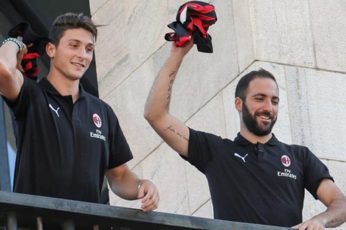 Dua pemain baru AC Milan, Gonzalo Higuain (kanan) dan Mattia Caldara, menyapa fans saat diperkenalkan di balkon Piazza Duomo, Milan, 3 Agustus 2018.