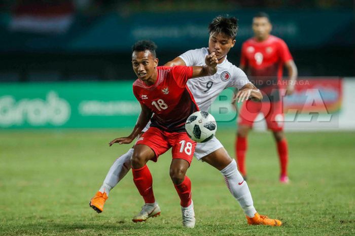   Winger timnas U-23 Indonesia, Irfan Jaya (depan) mencoba lepas dari kawalan pemain timnas U-23 Hong Kong pada laga Grup A sepak bola Asian Games 2018, 20 Agustus 2018.   