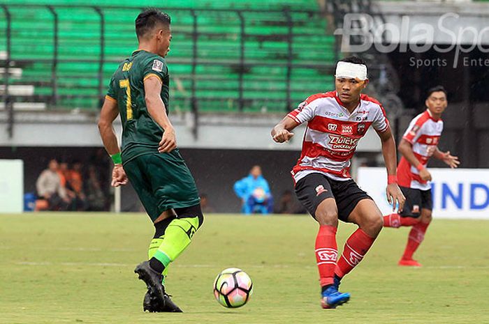 Gelandang Madura United, Asep Berlian (kanan), berupaya menghadang pergerakan pemain PS Tira Bantul, Ahmad Nufiandani, pada pekan kedua Piala Presiden 2018 Grup C di Stadion Gelora Bung Tomo Surabaya, Jawa Timur, Selasa (23/01/2018) sore.