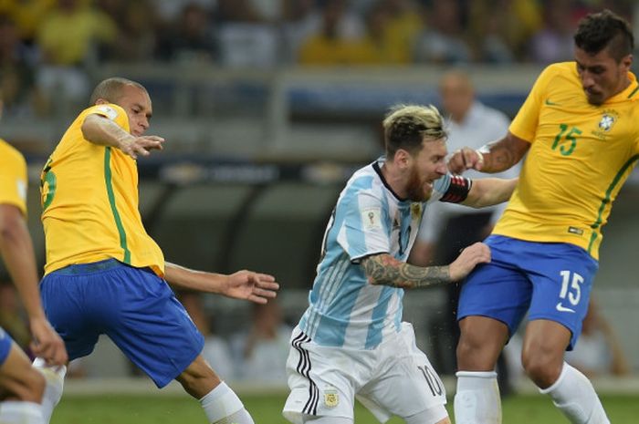 Megabintang Argentina, Lionel Messi (kedua dari kanan), berduel dengan gelandang Brasil, Paulinho, dalam laga Kualifikasi Piala Dunia 2018 Zona Amerika Selatan di Belo Horizonte, Brasil, pada 10 November 2016.  