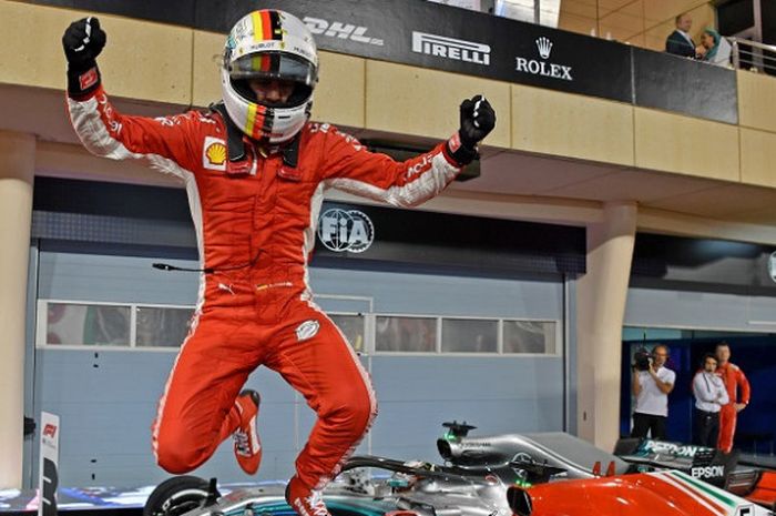 Pebalap Pebalap Ferrari, Sebastian Vettel bereaksi, setelah meraih podium pertama pada GP Bahrain yang berlangsung di Sirkuit Internasional Bahrain, Minggu (8/4/2018).