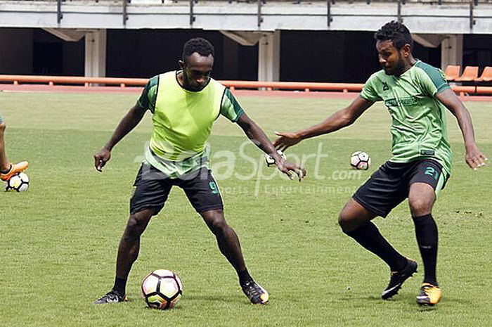 Dua pemain Persebaya, Ricky Kayame (kiri) berusaha melewati Fandli Imbiri pada sesi latihan gim di Stadion Gelora Bung Tomo Surabaya, Selasa (13/3/2018).