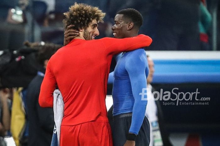   Duo Manchester United, Marouane Fellaini dan Paul Pogba saling berpelukan dalam laga Belgia Vs Prancis pada semifinal Piala Dunia 2018 di Saint-Petersburg Stadium, Selasa (10/7/2018)   