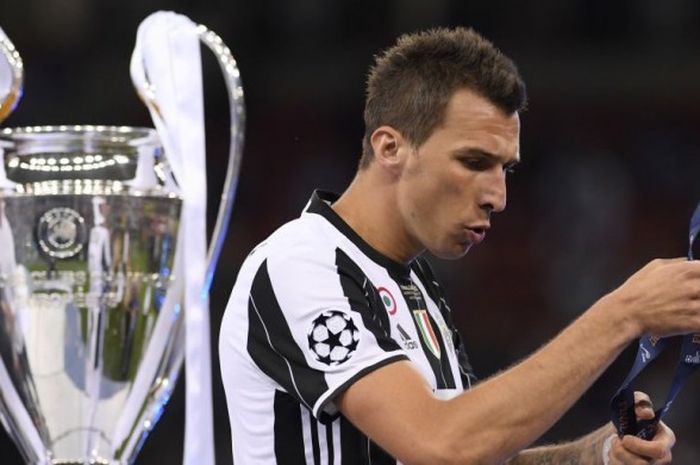 Pemain Juventus, Mario Mandzukic, menatap medali runner-up seusai kalah dari Real Madrid dalam laga final Liga Champions di National Stadium, Cardiff, Wales, pada 3 Juni 2017.