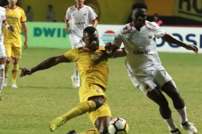 Penyerang Persija Jakarta, Osas Saha dijaga bek Sriwijaya FC, Marckho Sandi di Stadion Gelora Sriwijaya, Kota Palembang, Selasa (10/7/2018).