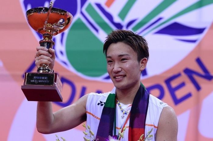 Pebulutangkis tunggal putra asal Jepang, Kento Momota, mengangkat trofi India Terbuka 2016 di atas podium. Unggulan kedua ini jadi juara seusai mengalahkan Viktor Axelsen (Denmark) pada laga final di Siri Fort Indoor Stadium, New Delhi, Minggu (3/4/2016).