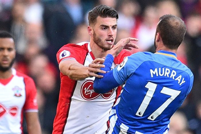 Striker Brighton and Hove Albion, Glenn Muray, berkonfrontasi dengan pemain belakang Southampton, Wesley Hoedt, saat kedua tim bersua pada partai Liga Inggris di Stadion St Mary, Minggu (29/10/2017).