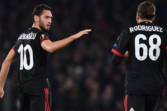 Gelandang AC Milan, Hakan Calhanoglu (kiri), merayakan gol yang ia cetak ke gawang Arsenal bersama Ricardo Rodríguez dalam laga leg 2 babak 16 besar Liga Europa di Stadion Emirates, London, Inggris, pada Kamis (15/3/2018).